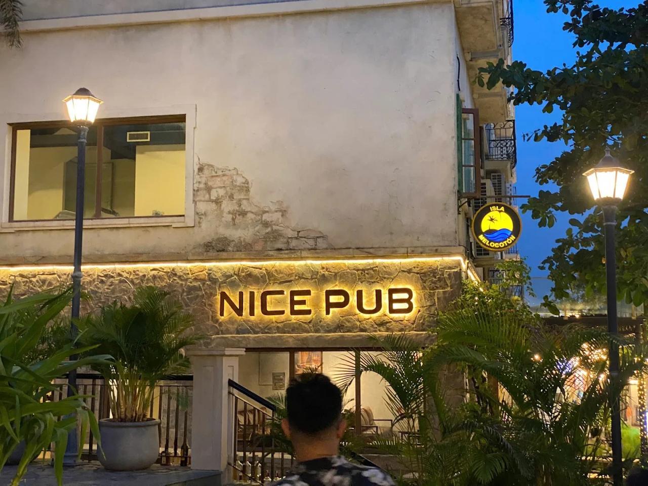 Nice Pub exterior with warm lighting and tropical plants